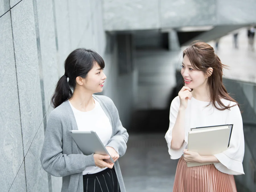資料を持って相談するキャリア女性同士